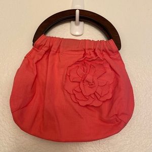 Small salmon pink colored bag with wooden handles